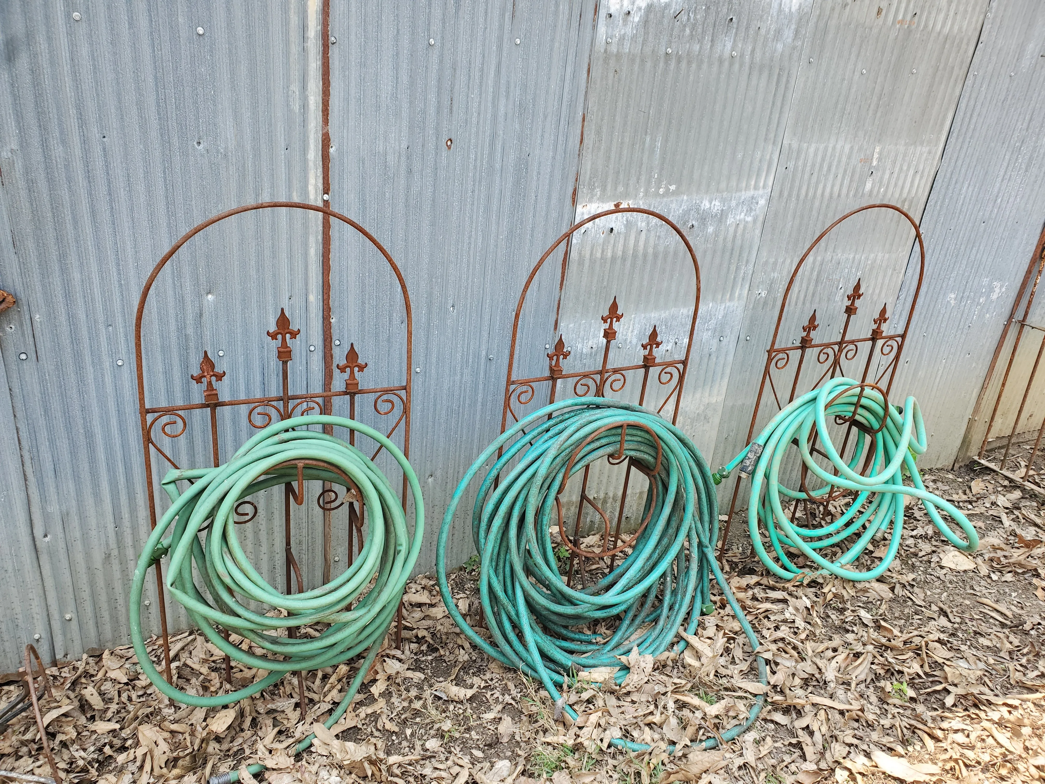 Iron Hose Wheel with 3 Finials & Stakes into the Ground
